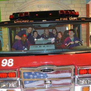 Cohort 1 with Deb, RN, BSN, posing with the fire truck at Lurie’s Children’s Hospital for the hospital to home transition education.